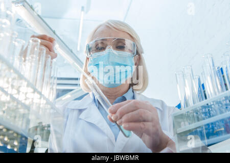 Senior chimico donna lavora con tubo di test in laboratorio Foto Stock