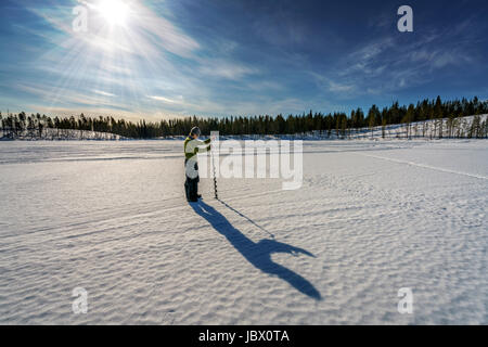 Pesca sul ghiaccio, Kangos, Lapponia, Svezia Foto Stock