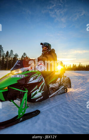 Motoslitte al tramonto, Kangos, Lapponia, Svezia Foto Stock