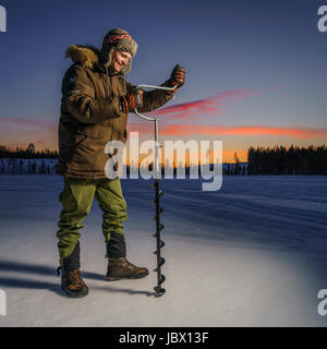 Pesca sul ghiaccio, Kangos, Lapponia, Svezia Foto Stock