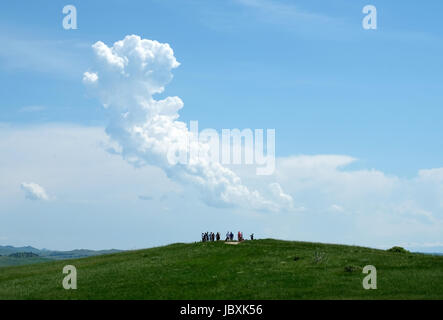 Visitatori stand su un punto elevato al Little Bighorn battlefield sito, Crow agenzia, Montana, USA. Foto Stock