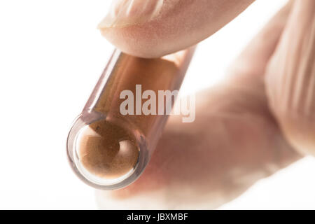 Brown sostanza in polvere nella provetta per analisi Foto Stock