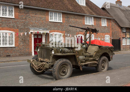 Vintage Guerra Mondiale 2 jeep parcheggiata in un'ambientazione autentica in un villaggio di Hampshire. Una mostra di lavoro per il D-Day evento revival in Southwick. Foto Stock