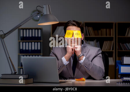 Uomo d'affari che soggiornano in ritardo per ordinare le priorità Foto Stock