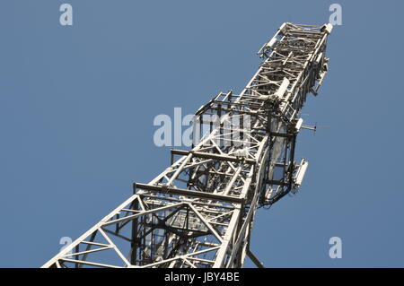 Torri di telecomunicazione con le antenne sul cielo blu chiaro Foto Stock