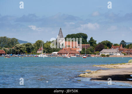 Chiesa della Santa Trinità e di edifici storici di Bosham, un villaggio costiero visto attraverso Chichester Porto sulla costa sud, West Sussex, in Inghilterra Foto Stock