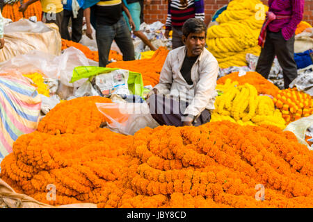 I mucchi di coloratissimi fiori marygold sono venduti dai venditori sul mercato dei fiori giornaliera al di sotto di quella di Howrah bridge Foto Stock