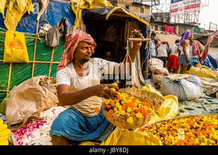 I mucchi di coloratissimi fiori marygold sono venduti dai venditori sul mercato dei fiori giornaliera al di sotto di quella di Howrah bridge Foto Stock