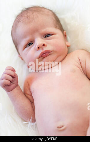 Kleines Baby kleinkind neugeborenes nackt auf einem weißen cadde als Detal Foto Stock
