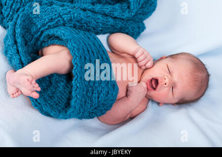 Neugeborenes Baby in einen schal gewickelt schläft nackt als Nahaufnahme Foto Stock