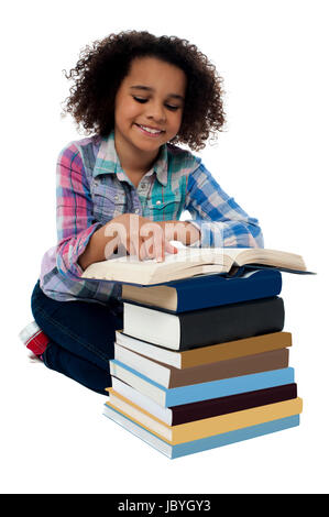 Bambina in ginocchio e la lettura di un libro Foto Stock