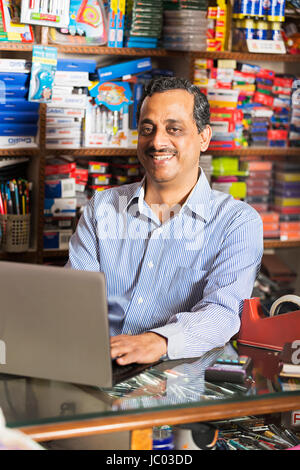 1 indian negoziante donna utilizzando laptop in negozio stazionario Foto Stock