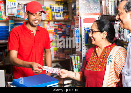 Negoziante e cliente dando rupie denaro in shop shopping e commercio al dettaglio Foto Stock