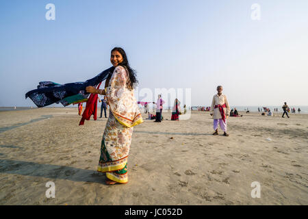 Le donne sono la sua essiccazione sari sulla spiaggia di ganga sagar, celebrando i maghi purnima festival Foto Stock