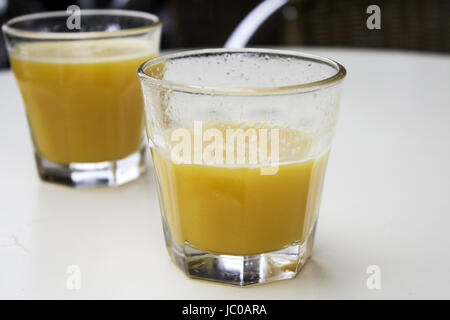 Con bicchieri di succo d'arancia con vitamine in bar, frutta Foto Stock