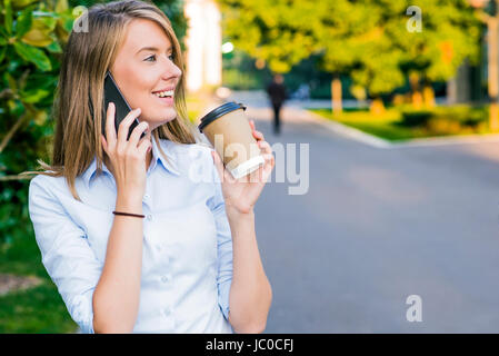 Business, tecnologia e persone concetto - imprenditrice sorridente con lo smartphone su edificio per uffici Foto Stock