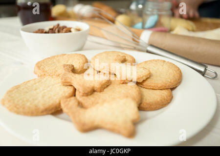 Foto macro di biscotti appena sfornati giacente sul piatto bianco in cucina Foto Stock