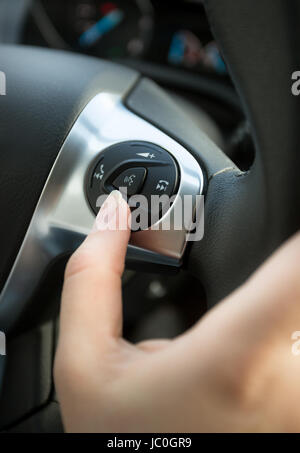 Primo piano del conducente premendo il tasto telefono sulla macchina volante Foto Stock