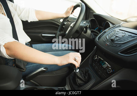 Primo piano della donna di un cambio marcia stick e la guida di una vettura Foto Stock