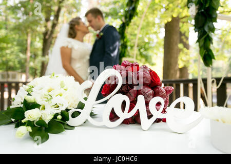 Primo piano del segno decorativo 'amore' sulla tabella alla cerimonia di nozze Foto Stock