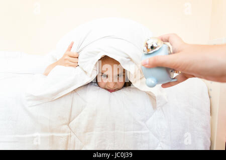 Bella bionda bambina triste e insonni arrabbiato che mostra orologio sveglia  tempo di prepararsi per la scuola in difficoltà di svegliarvi al mattino  bambini Foto stock - Alamy