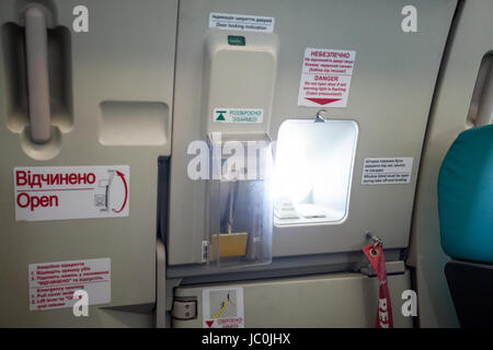 Foto di uscita di emergenza porta con oblò in aereo Foto Stock