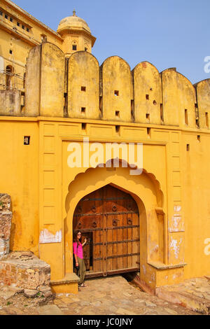 Giovane donna in piedi dal gate in Forte Amber vicino a Jaipur, Rajasthan, India. Forte Amber è la principale attrazione turistica nella zona di Jaipur. Foto Stock