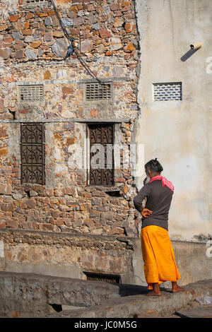 Locali di uomo in piedi dalla sua casa a Jaipur, India. Jaipur è il capitale e la più grande città dello stato indiano del Rajasthan. Foto Stock