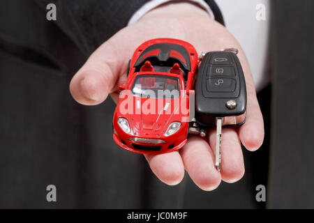Auto rossa e la chiave in imprenditore il canto close up Foto Stock
