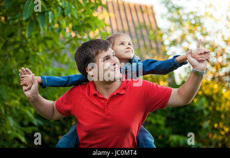 Closeup ritratto dell'uomo gioca con la figlia seduto sulle sue spalle Foto Stock