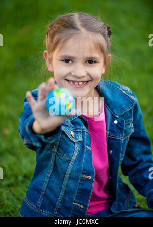 Closeup ritratto di sorridente ragazza con globo in mano Foto Stock