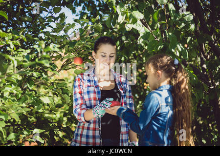 Giovane madre e figlia giardinaggio al giorno d'estate e di sole Foto Stock