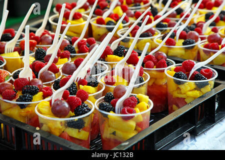 Insalata di frutta in bicchieri di plastica con forche Foto Stock