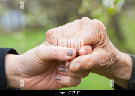 Chiudere l immagine di una giovane donna di mani tenendo un anziana donna mani Foto Stock
