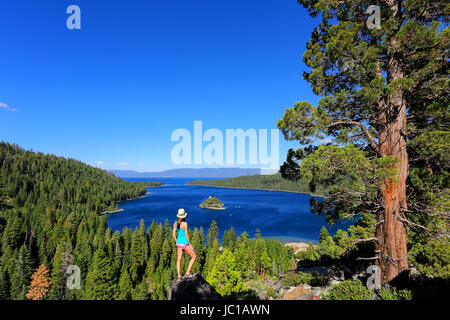 Giovane donna godendo della vista di Emerald Bay sul Lago Tahoe, California, Stati Uniti d'America. Il lago Tahoe è il più grande lago alpino in America del Nord Foto Stock