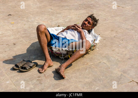 Un lavoratore il mercato dei fiori è dormire sul pavimento nel suo cesto Foto Stock