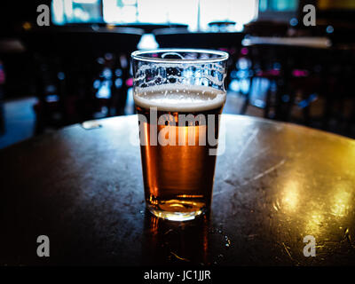 Vintage cercando pinta di inglese bitter ale in un pub Foto Stock