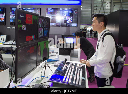 Shanghai, Cina. Xiii Giugno, 2017. Un visitatore orologi schermi alla Associazione Nazionale delle emittenti televisive (NAB) mostra a Shanghai, Cina orientale, Giugno 13, 2017. Come una delle attività del 2017 Shanghai International Film e TV Festival, il NAB Show Shanghai ha attirato più di 150 aziende. Credito: Du Natalino/Xinhua/Alamy Live News Foto Stock