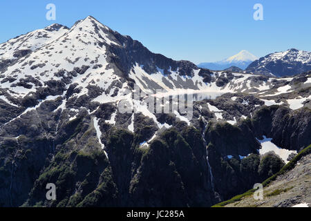 Bellissimo paesaggio di montagna da Arco Iris picco a Cochamo Parco Nazionale guardando un lago glaciale con il vulcano Osorno nel lontano indietro Foto Stock
