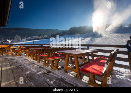 Ristorante tradizionale con terrazza aperta sulla stazione sciistica a giornata di sole Foto Stock