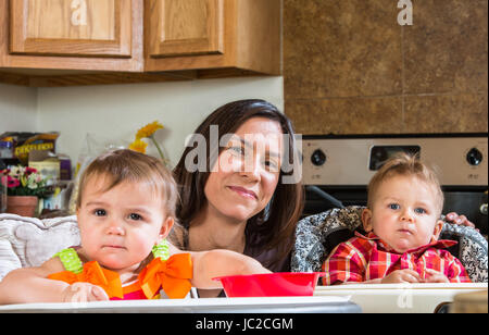 Una madre in cucina pone con neonati Foto Stock