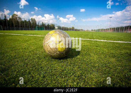 Vecchio shabby soccer ball giacente su erba artificiale campo Foto Stock