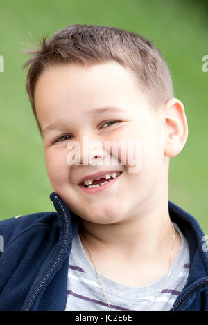 Ragazzo all'aperto senza superiore di due denti con un sorriso Foto Stock