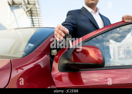 Primo piano della bella Venditore auto che dà le chiavi Foto Stock
