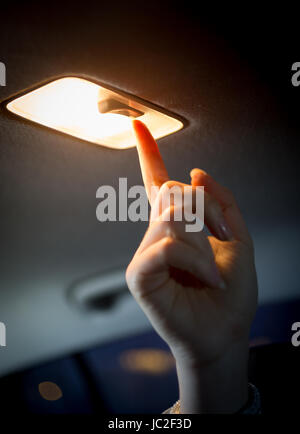 Primo piano della donna girando in luce in auto salon Foto Stock