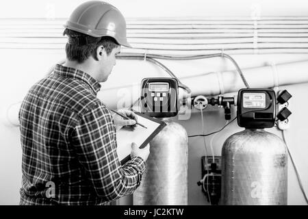 Bianco e nero colpo di ispettore maschio di controllo dell'apparecchiatura di fabbrica Foto Stock