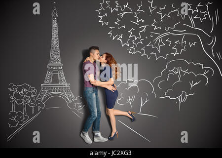 Happy valentines love story concetto di una coppia romantica a Parigi baciare sotto la Torre Eiffel contro gesso disegni dello sfondo. Foto Stock