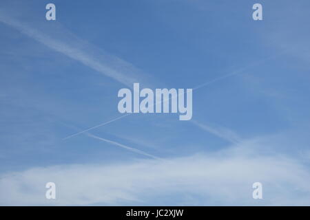 Sentieri a getto, noto come chemtrails contrails o oltre il cielo blu sullo sfondo Foto Stock
