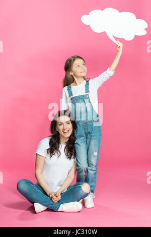 Bella felice madre e figlia con vuoto discorso bolla in rosa Foto Stock