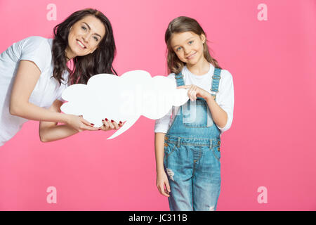 Bella sorridente madre e figlia holding vuoto discorso bolla in rosa Foto Stock